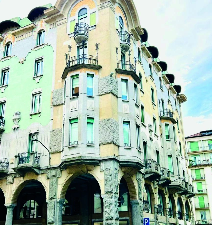 Palazzo storico ad angolo con balconi e portici