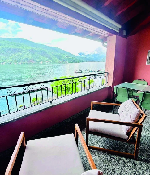 Terrazza coperta con poltrone e vista panoramica sul lago